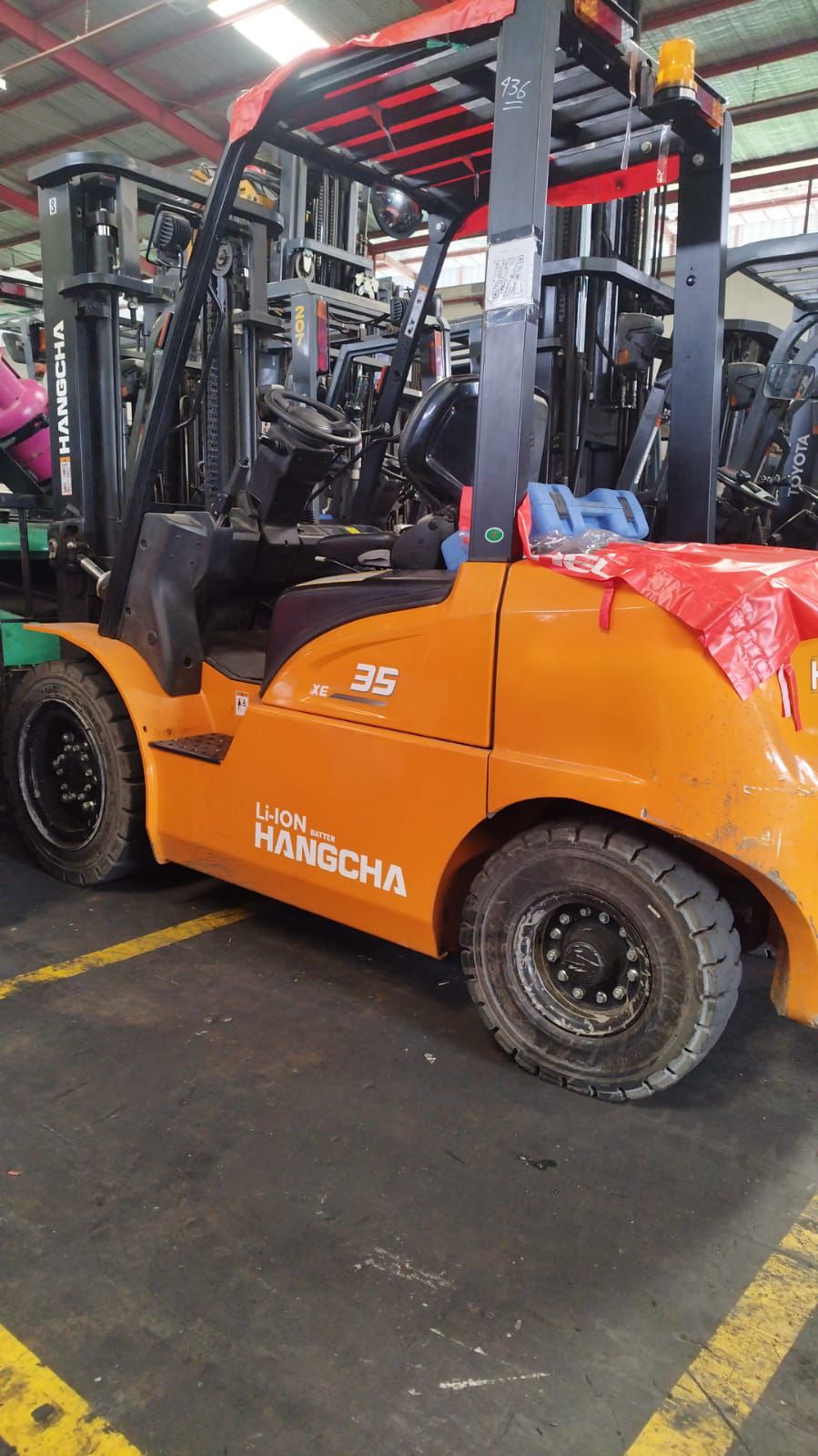 Forklift oranye dalam gudang armada siap sewa
