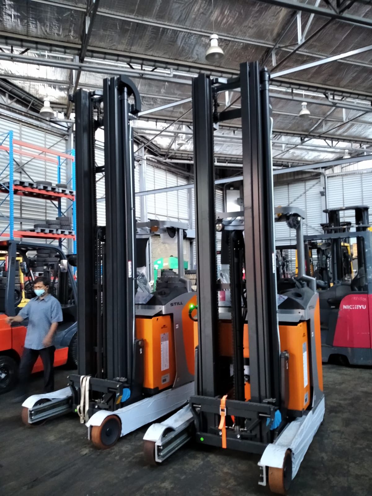 Forklift merah besar dalam area indoor dengan pencahayaan workshop