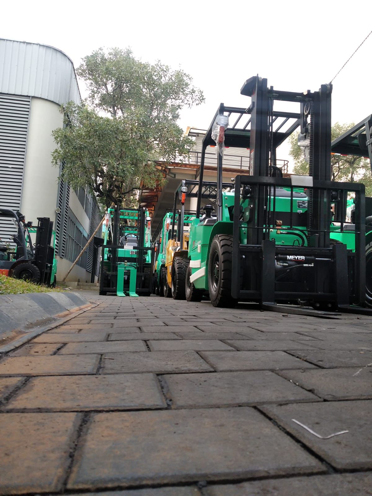 Forklift merah dan hitam di area warehouse aktif