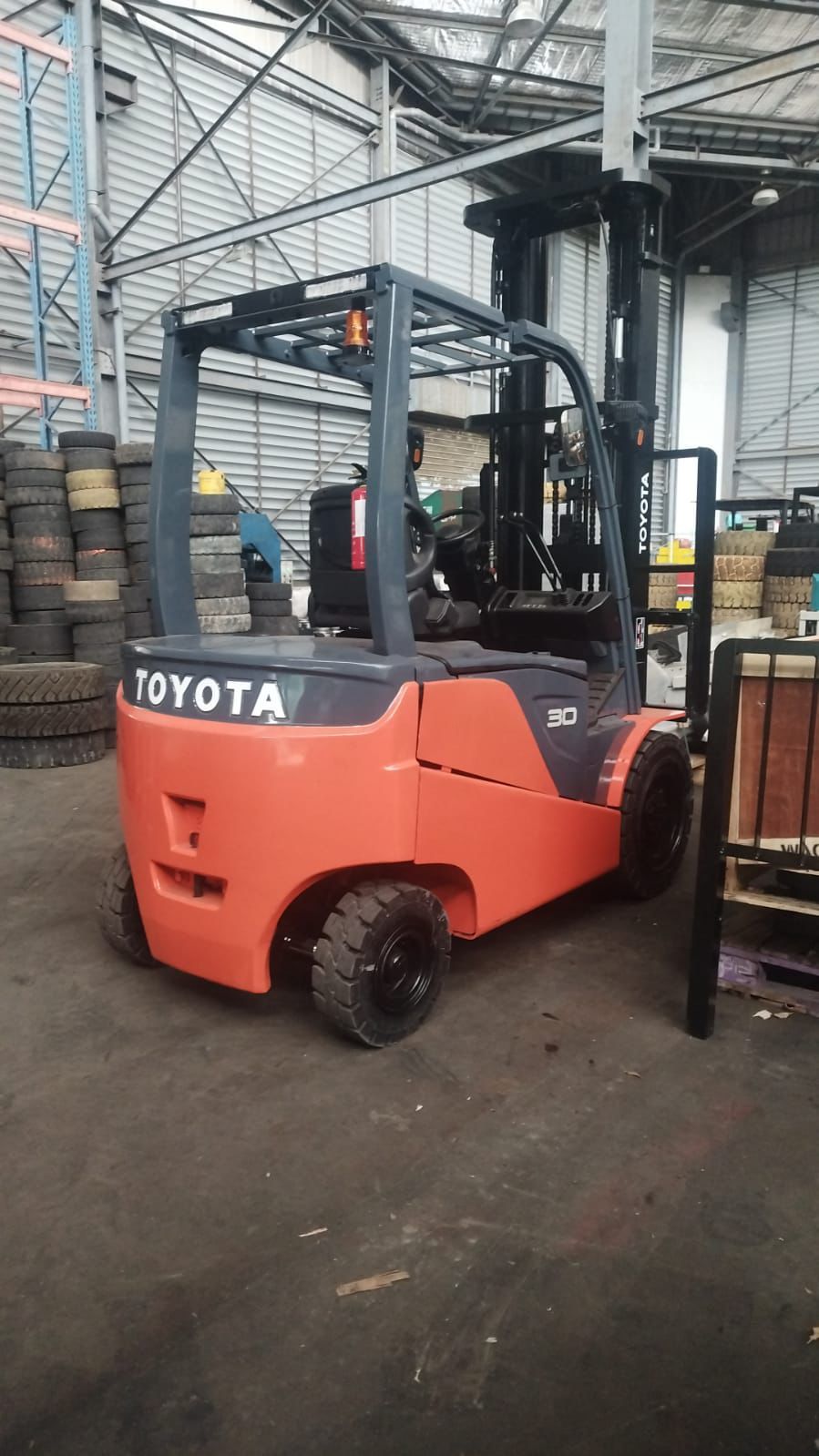 Forklift merah dalam area workshop dengan nuansa hangat