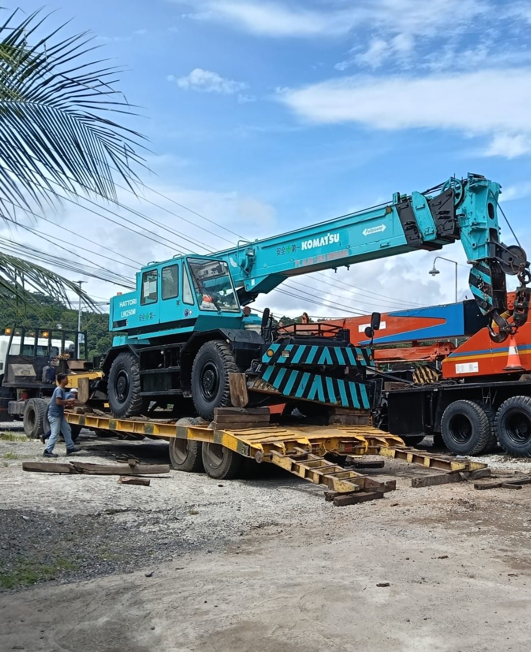 Rough terrain crane Komatsu LW250M biru dimuat ke trailer lowbed untuk mobilisasi unit