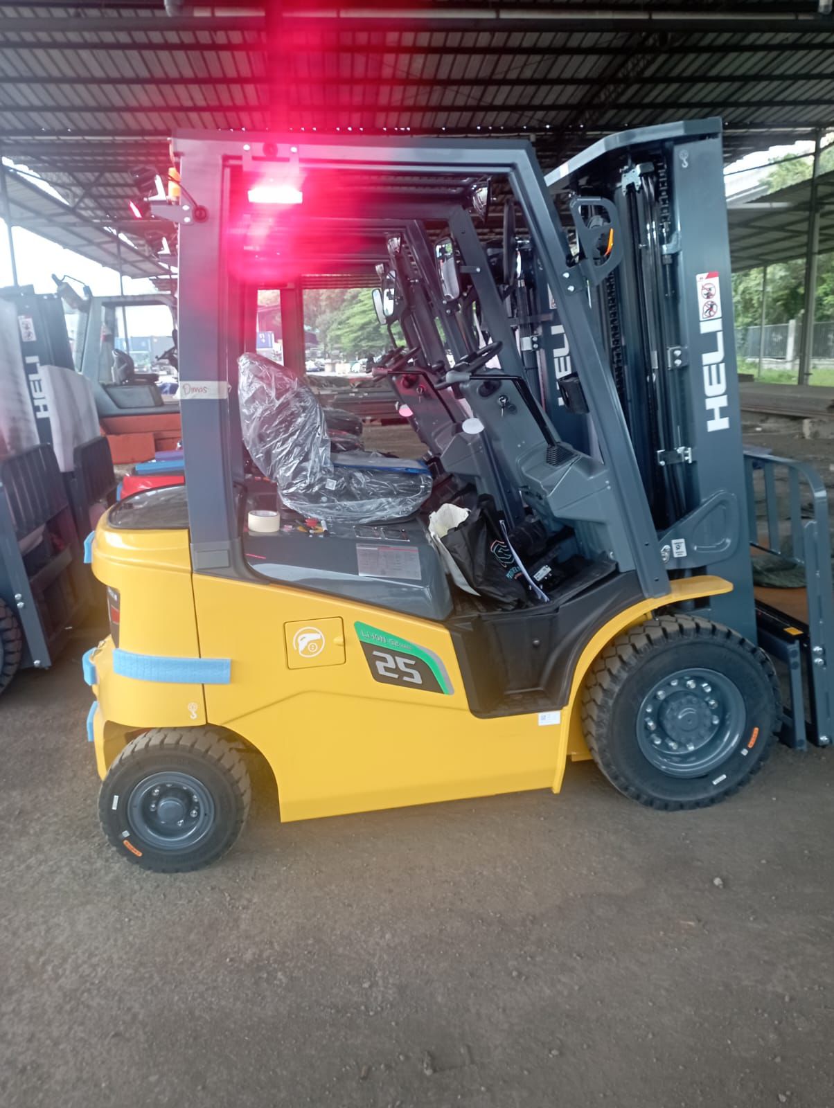 Forklift kuning dalam area workshop siap operasional